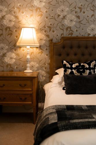 a bedroom with a bed and a lamp on a nightstand at Lemon Tree Lane in Port Elizabeth