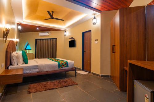 a bedroom with a bed and a ceiling fan at Treebo Premium Mowgli's Den, Pench in Khawāsa