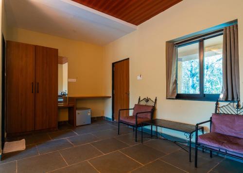 a hospital room with two chairs and a window at Treebo Premium Mowgli's Den, Pench in Khawāsa
