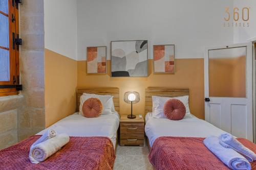 two beds sitting next to each other in a room at Maltese Maisonette in Historic Isla with Sea Views by 360 Estates in Senglea
