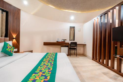 a hotel room with a bed and a desk at Treebo Premium Mowgli's Den, Pench in Khawāsa
