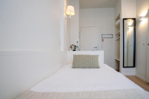 a white bedroom with a large white bed in it at Hotel du Bassin in Ostend