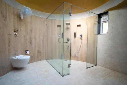 a bathroom with a shower with a toilet and a glass shower stall at Treebo Premium Mowgli's Den, Pench in Khawāsa