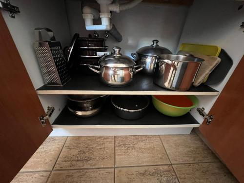 a shelf with pots and pans in a kitchen at Penzion pod Vlekem Dolní Morava in Dolní Morava