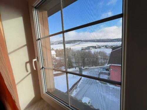 a window with a view of a snow covered field at Penzion pod Vlekem Dolní Morava in Dolní Morava