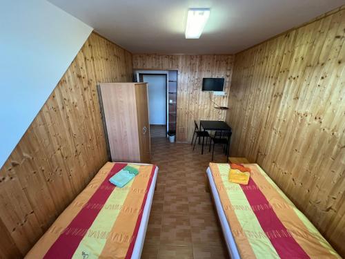 a small room with two beds and a table at Penzion pod Vlekem Dolní Morava in Dolní Morava