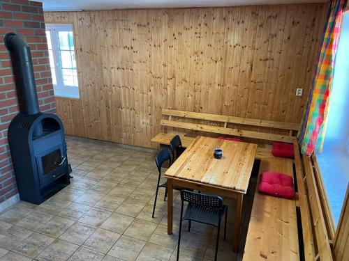 a room with a wooden table and a wood stove at Penzion pod Vlekem Dolní Morava in Dolní Morava
