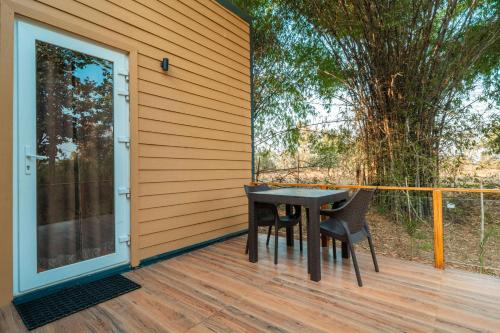 a patio with a table and two chairs on a deck at Treebo Premium Mowgli's Den, Pench in Khawāsa