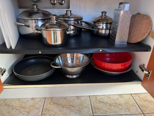 a shelf in a kitchen with pots and pans at Penzion pod Vlekem Dolní Morava in Dolní Morava