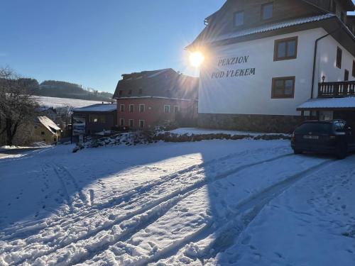 a snow covered road in front of a building at Penzion pod Vlekem Dolní Morava in Dolní Morava