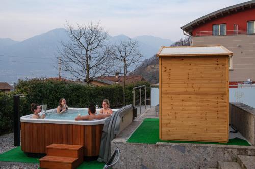 three women in a hot tub in a backyard at Lake Hotel La Pieve in Pisogne