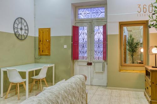 a room with a table and chairs and a window at Maltese Maisonette in Historic Isla with Sea Views by 360 Estates in Senglea