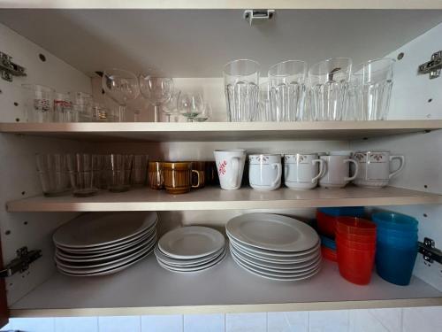 a shelf filled with plates and cups and glasses at Penzion pod Vlekem Dolní Morava in Dolní Morava