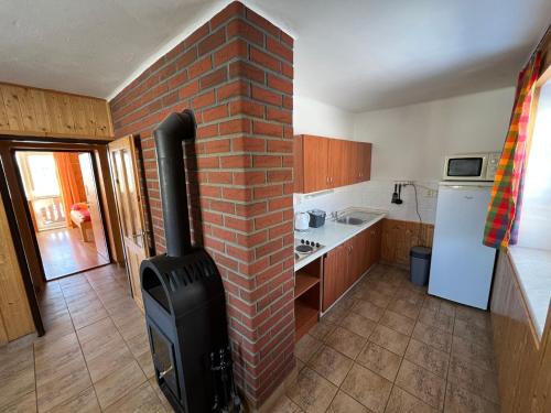 a kitchen with a brick wall and a stove at Penzion pod Vlekem Dolní Morava in Dolní Morava