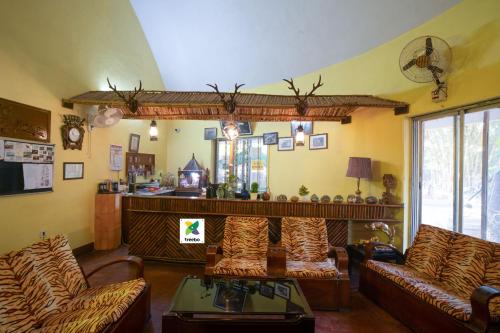 a living room with couches and a table at Treebo Premium Mowgli's Den, Pench in Khawāsa