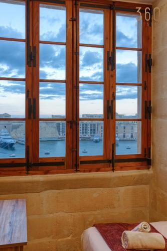 a bedroom with a window with a view of a harbor at Maltese Maisonette in Historic Isla with Sea Views by 360 Estates in Senglea