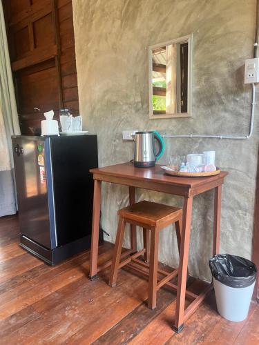 a table and stool next to a small refrigerator at Phayam Valley Homestay in Ko Phayam