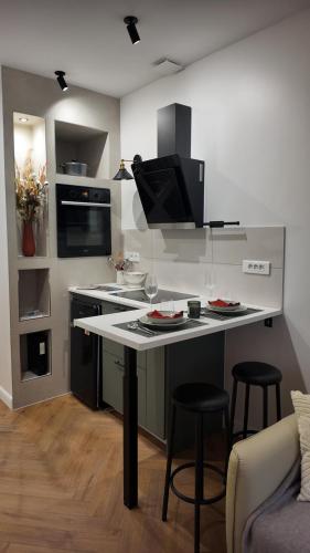 une cuisine avec un comptoir avec deux tabourets et une table dans l'établissement Stella di VAROS, à Strasbourg