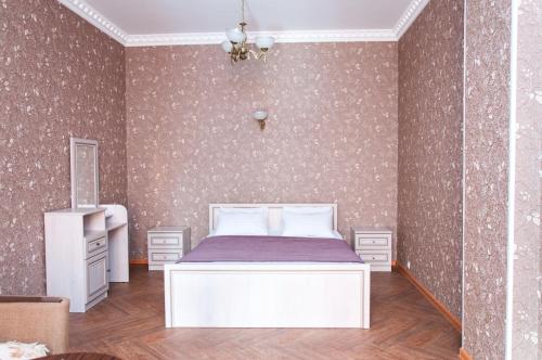 a bedroom with a white bed in a room with wallpaper at Inndays Apartments on Demonstratsii in Tula