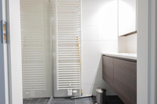 a bathroom with a shower with white shutter doors at Duinhof VIII D201 in Cadzand