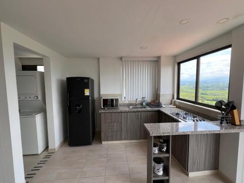 a kitchen with a black refrigerator and a window at Apartamento Vista Hermosa Parque del Café in Montenegro