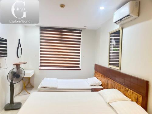 a bedroom with two beds and a tv on the wall at Hanoi Gold Hotel in Hanoi