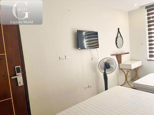 a bedroom with a fan and a tv on the wall at Hanoi Gold Hotel in Hanoi