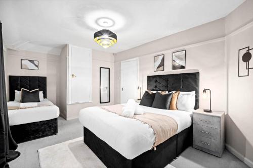 een slaapkamer met 2 bedden en witte muren bij Stylish Three Bedroom House - Accommodates 7 - Parking Available - Garden - Recently Renovated - Top Rated - 162S in Birmingham