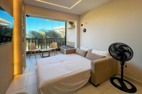 a living room with a couch and a fan at VG Sun Cumbuco Studio Luxo 4 Pessoas in Paracumbuca