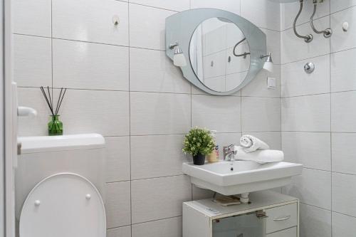 a bathroom with a toilet and a sink and a mirror at Address Apartment Sarajevo in Sarajevo