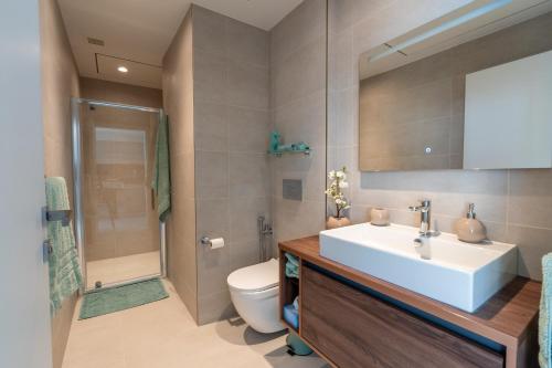 a bathroom with a sink and a toilet and a shower at Oasis on the 27th, Mercury Tower in St Julian's