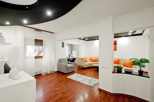 a living room with white walls and wood floors at Ultracentral Apartment Braila in Brăila