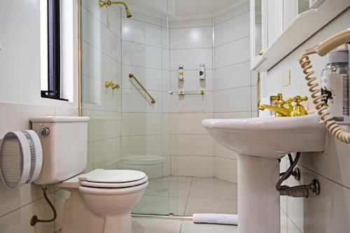 a bathroom with a toilet and a sink and a shower at Transamerica Executive Higienópolis in Sao Paulo