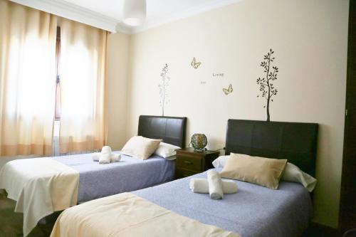 a bedroom with two beds with white towels on them at A 15 minutos Granada, piscina, jacuzzi, barbacoa in Güevéjar