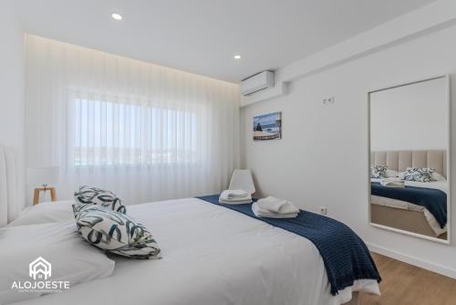 a white bedroom with a large bed and a window at Apartamento Vista Mar - 4 bedroom apt - Sea View in Santa Cruz