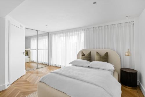 a white bedroom with a large white bed with pillows at Navigation Yard in Chelmsford