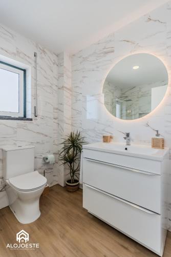 a white bathroom with a toilet and a mirror at Apartamento Vista Mar - 4 bedroom apt - Sea View in Santa Cruz