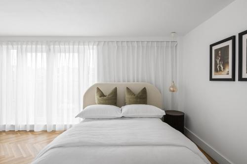 a white bedroom with a large white bed with pillows at Navigation Yard in Chelmsford