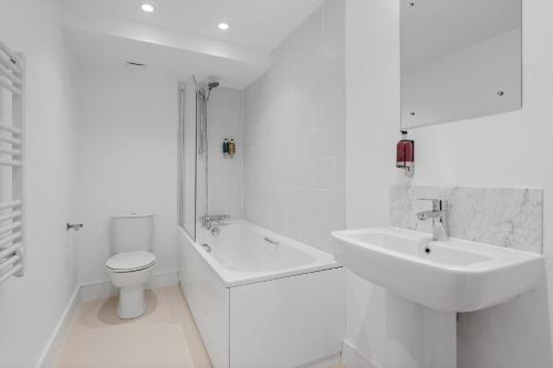 a white bathroom with a sink and a toilet at Navigation Yard in Chelmsford