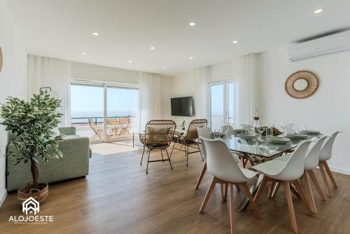 a dining room and living room with a table and chairs at Apartamento Vista Mar - 4 bedroom apt - Sea View in Santa Cruz