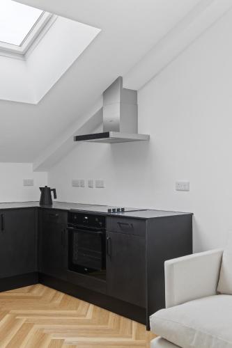 a kitchen with black cabinets and a stove at Navigation Yard in Chelmsford