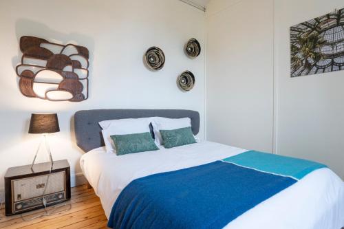 une chambre avec un grand lit avec une couverture bleue dans l'établissement APPARTEMENT ARTEM - Centre - Université, à Caen