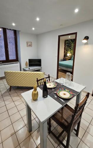 une table à manger et des chaises dans un salon dans l'établissement Appartement au cœur de Marcillac-Vallon, à Marcillac-Vallon