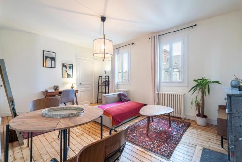 un salon avec une table et un canapé dans l'établissement APPARTEMENT ARTEM - Centre - Université, à Caen