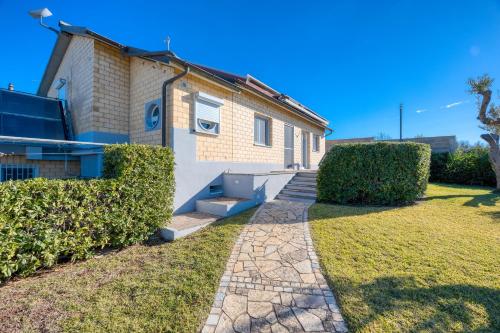 a brick house with a pathway in front of it at Residence Margherita in Ugento