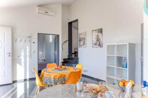 a dining room with a table and yellow chairs at Residence Margherita in Ugento