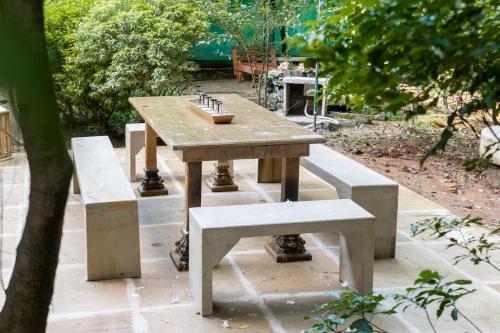 a picnic table and benches in a garden at Gopagiri Homestay - Gwalior in Gwalior