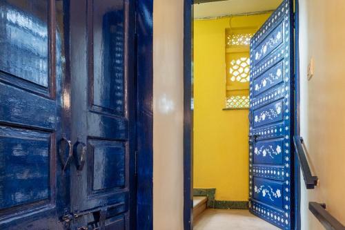 a room with a blue door and a yellow wall at Gopagiri Homestay - Gwalior in Gwalior