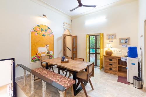 a dining room with a wooden table and chairs at Gopagiri Homestay - Gwalior in Gwalior