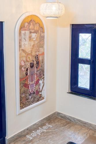 a painting on a wall next to a window at Gopagiri Homestay - Gwalior in Gwalior